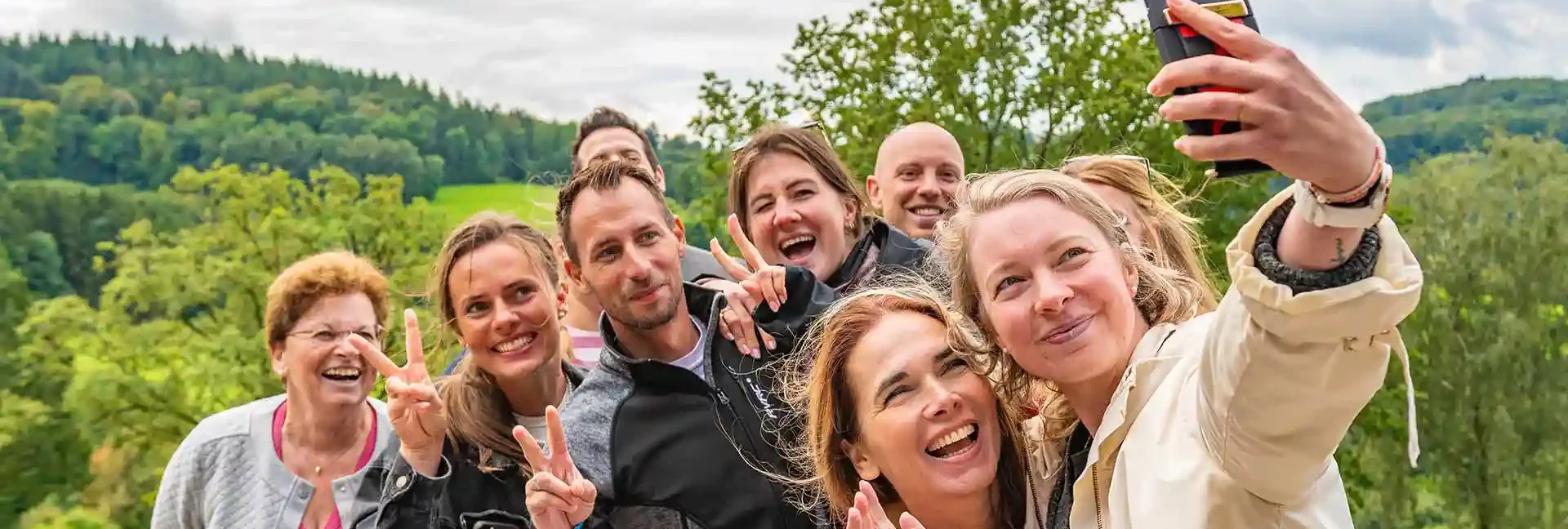 Eine Gruppe von Menschen macht ein Selfie im Schwarzwald am Standort der Sommerrodelbahn Gutach.
