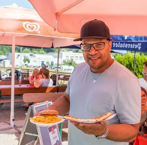 Ein Mann schaut lächelnd im Biergarten der Sommerrodelbahn Gutach in die Kamera.