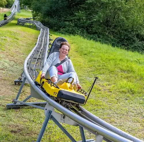 Eine ältere Damen freut sich sichtlich beim Herunterfahren der Sommerrodelbahn Gutach.