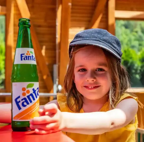 Im Biergarten der Sommerrodelbahn Gutach sitzt ein Kind vor einem Getränk.